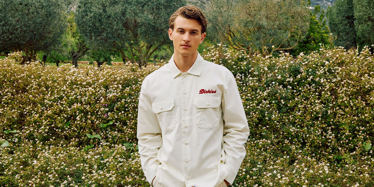man in cream dickies overshirt standing in garden