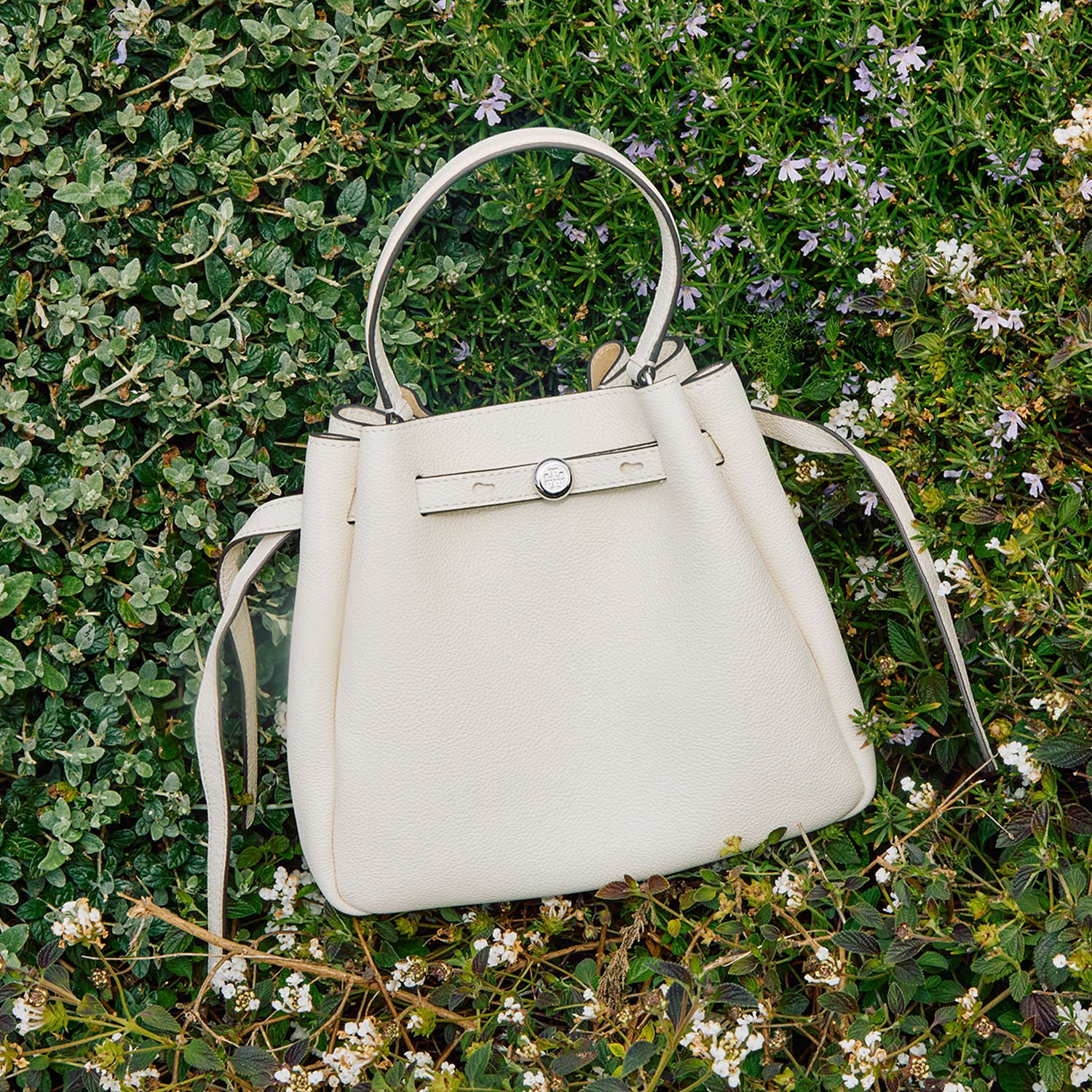 white designer handbag on grassy background